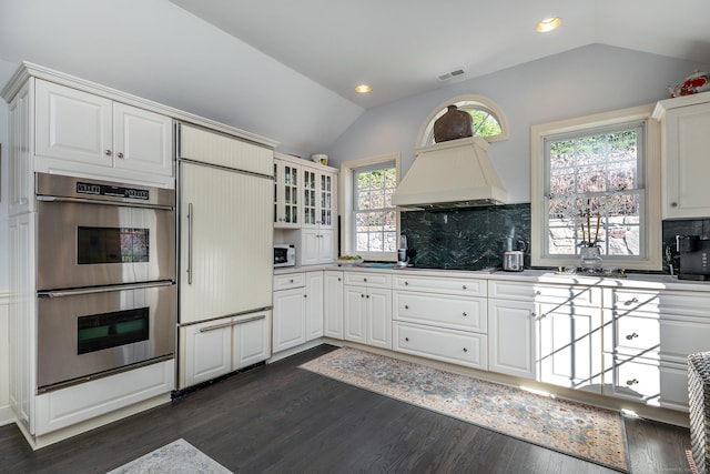 52 S Lake Shore Dr, Brookfield, CT 06804 - kitchen with paneled built in fridge, double oven, lofted ceiling, custom range hood, and decorative backsplash
