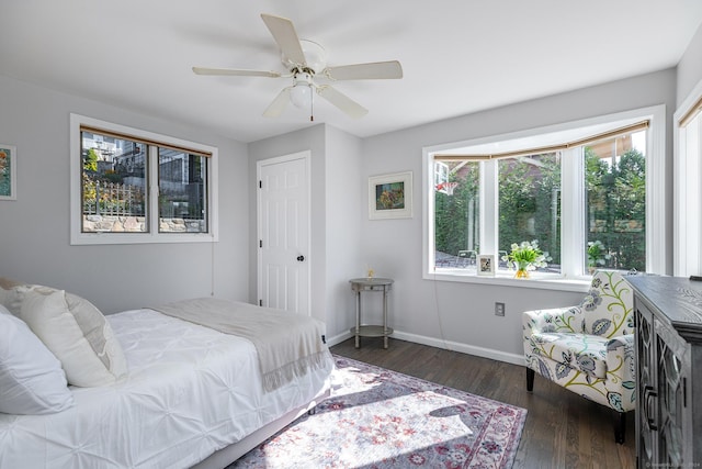 bedroom with ceiling fan, baseboards, and wood finished floors