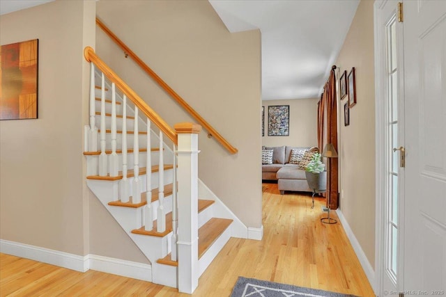 stairs featuring wood finished floors and baseboards