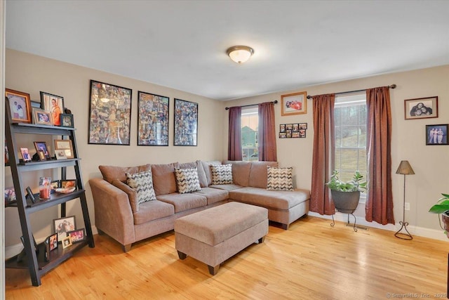 living area with light wood-type flooring and baseboards