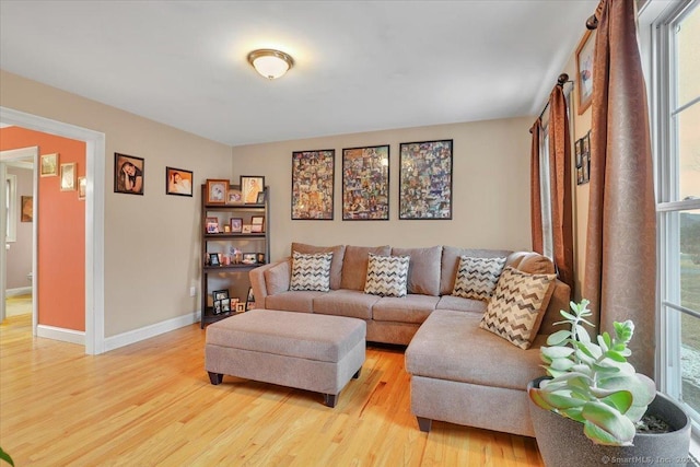 living area featuring a wealth of natural light, baseboards, and light wood finished floors