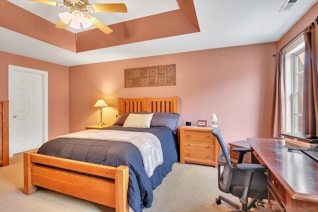 bedroom with visible vents, carpet flooring, a raised ceiling, and ceiling fan