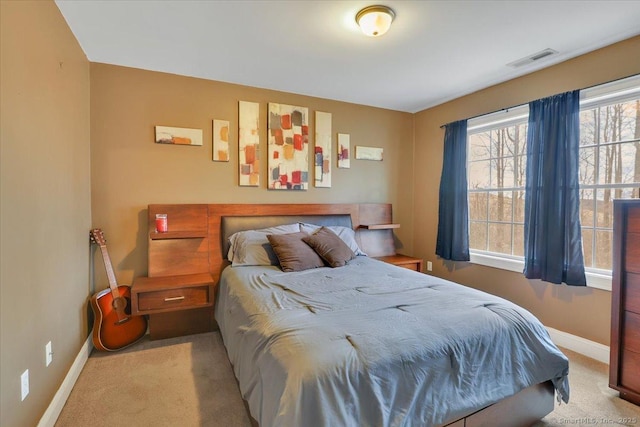 carpeted bedroom with visible vents and baseboards