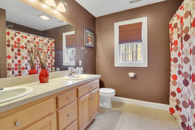 full bath featuring double vanity, toilet, baseboards, and a sink