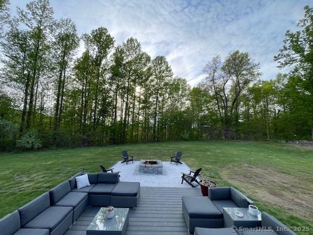 exterior space featuring a patio area, a lawn, and an outdoor living space with a fire pit