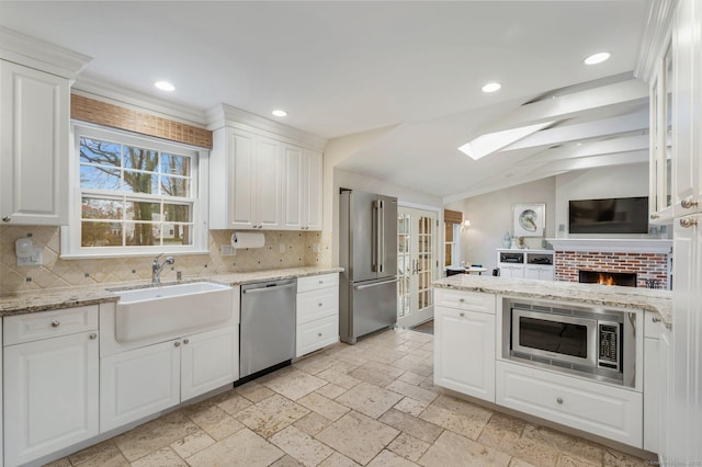 24 Laforge Rd, Darien, CT 06820 - kitchen with appliances with stainless steel finishes, decorative backsplash, vaulted ceiling, white cabinetry, and recessed lighting
