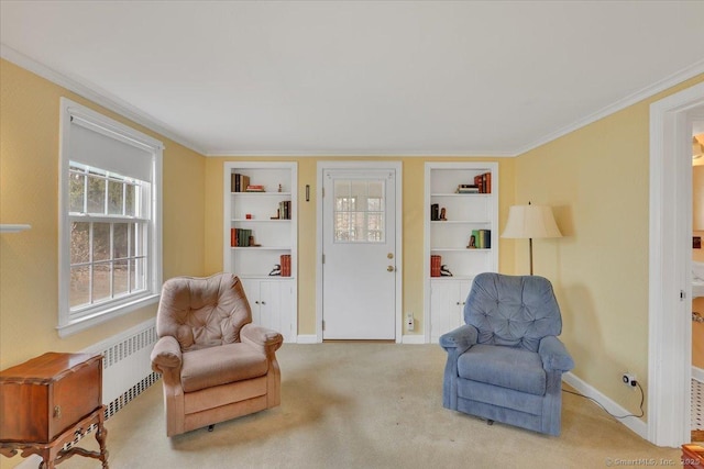 living area with built in shelves, baseboards, and ornamental molding