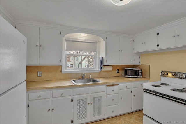 kitchen featuring a sink, white appliances, white cabinetry, and light countertops