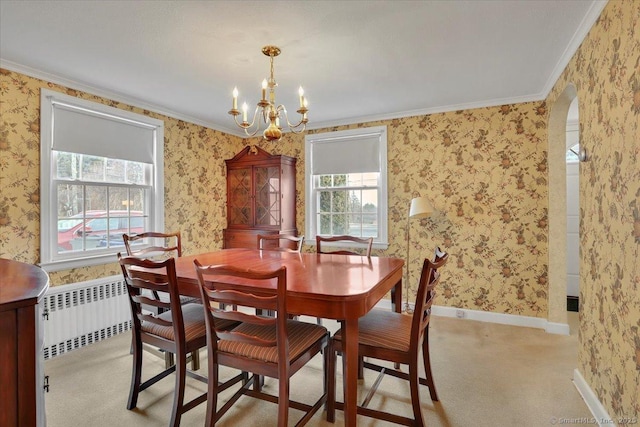 carpeted dining space featuring baseboards, arched walkways, radiator, and wallpapered walls