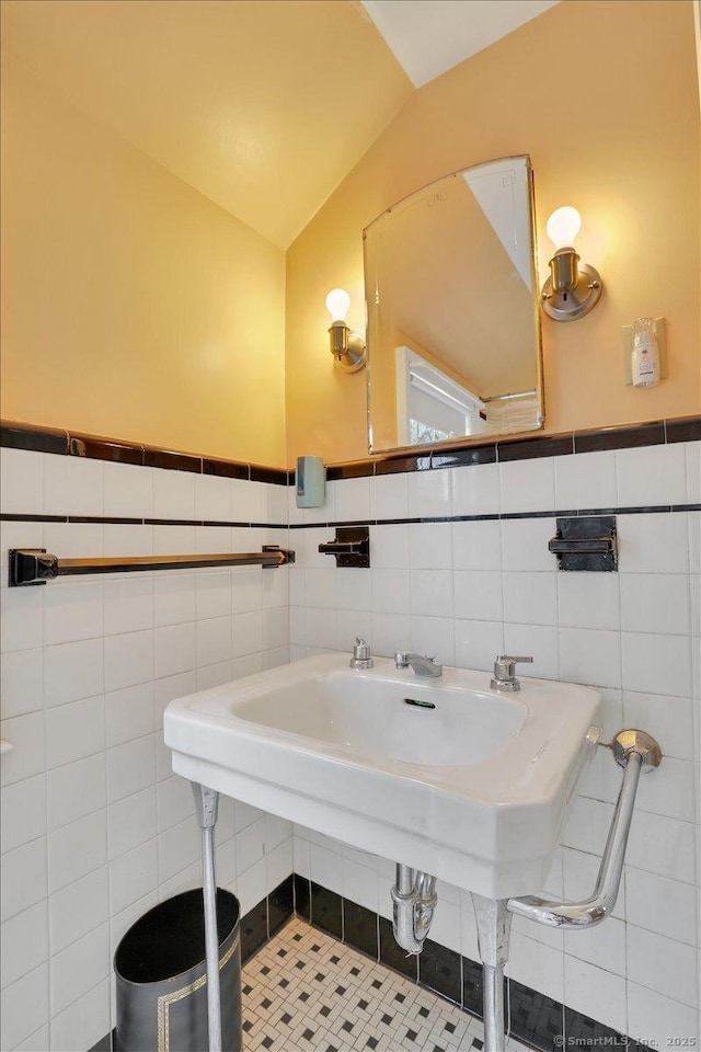 bathroom with lofted ceiling and tile walls