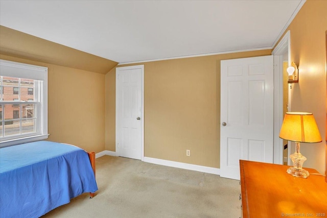 bedroom featuring a closet, baseboards, light colored carpet, and lofted ceiling