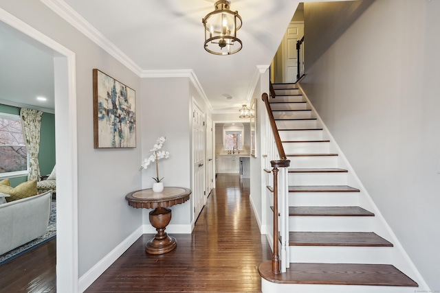 entryway featuring a chandelier, baseboards, ornamental molding, stairway, and wood-type flooring