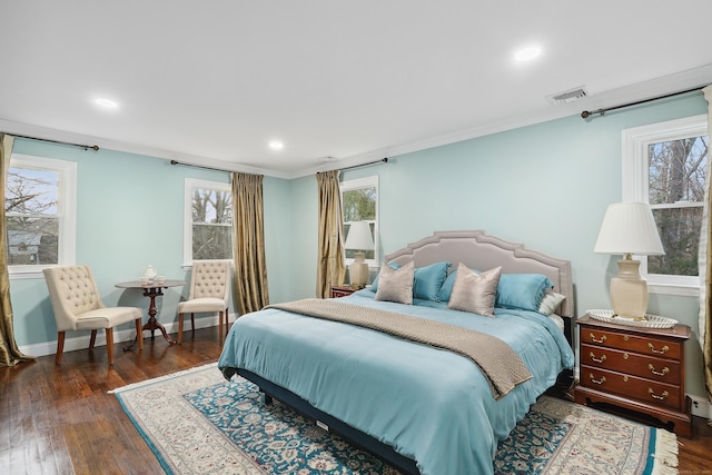 bedroom featuring wood-type flooring, multiple windows, visible vents, and baseboards