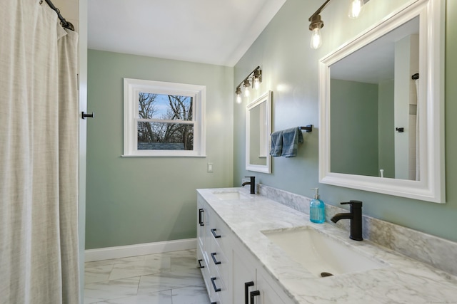 full bathroom featuring double vanity, marble finish floor, baseboards, and a sink