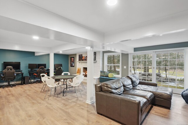 living room featuring light wood-type flooring and a brick fireplace