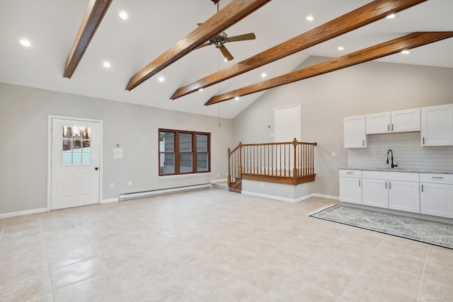 unfurnished living room with ceiling fan, baseboards, baseboard heating, and a sink