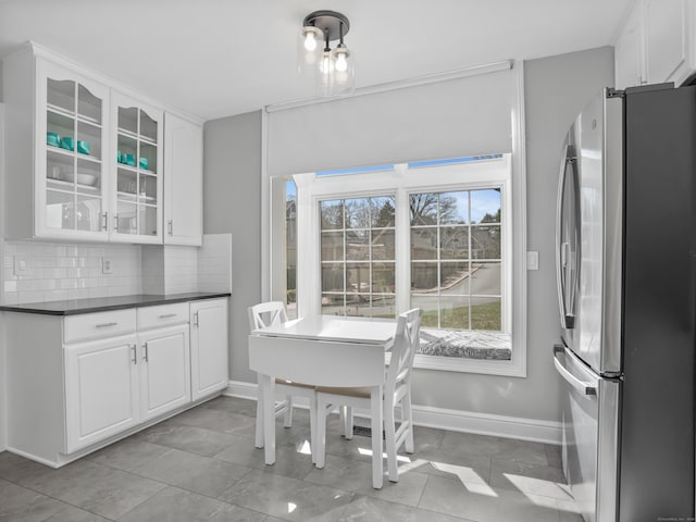 dining space featuring light tile patterned flooring and baseboards