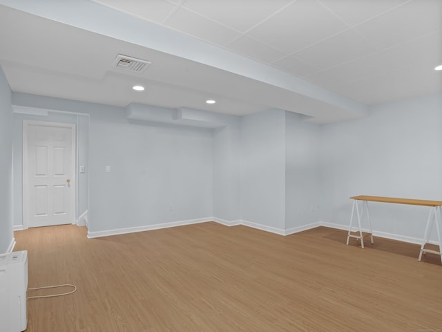 finished below grade area featuring light wood-style flooring, recessed lighting, baseboards, and visible vents