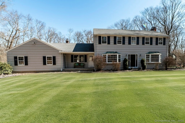 view of front of house with a front yard and a chimney