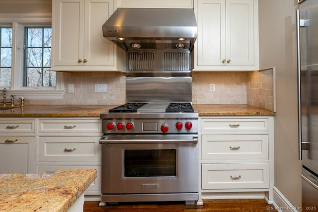 kitchen with light stone countertops, appliances with stainless steel finishes, exhaust hood, and white cabinets