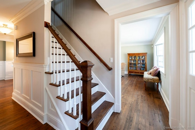 stairway featuring a wainscoted wall, wood finished floors, a decorative wall, and ornamental molding