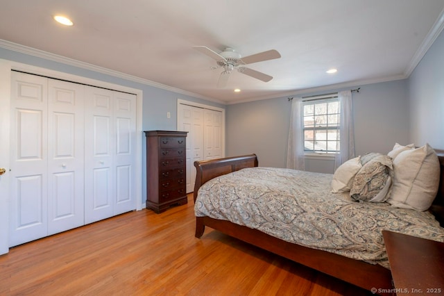 bedroom with recessed lighting, multiple closets, crown molding, and light wood finished floors