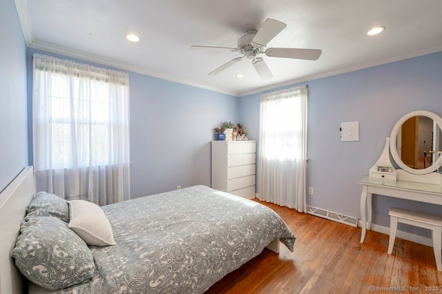 bedroom with baseboards, wood finished floors, ornamental molding, and a ceiling fan