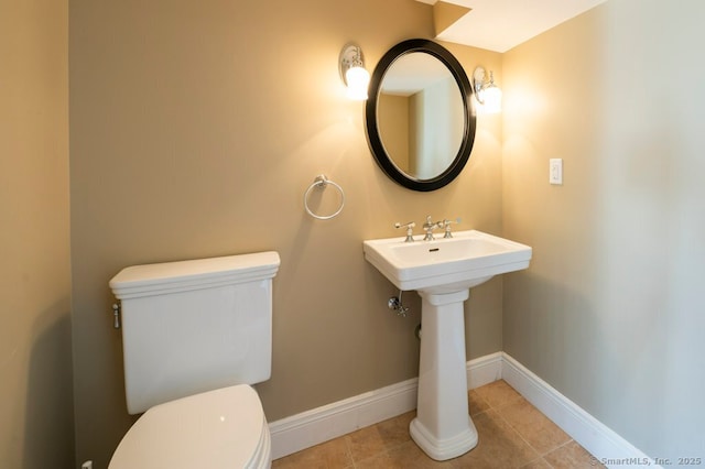 bathroom featuring tile patterned flooring, toilet, and baseboards