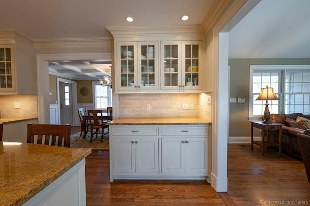 kitchen featuring light stone countertops, dark wood finished floors, white cabinets, and ornamental molding