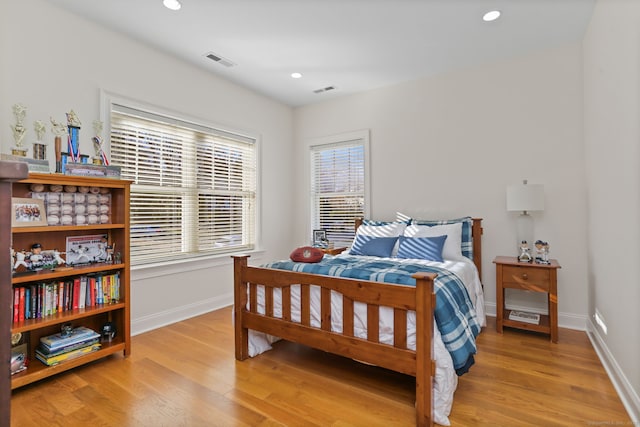 bedroom featuring visible vents, baseboards, and wood finished floors