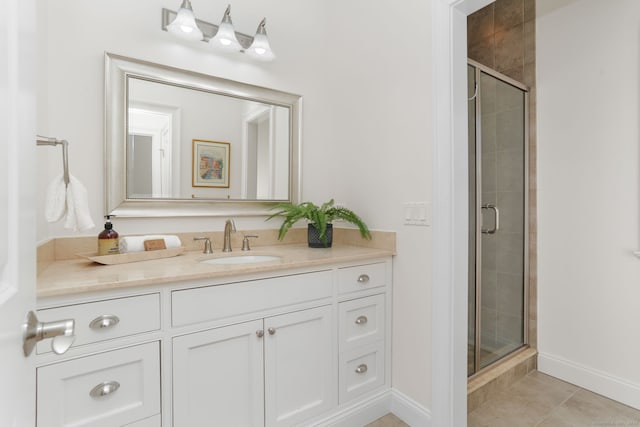 full bath featuring tile patterned floors, baseboards, a stall shower, and vanity