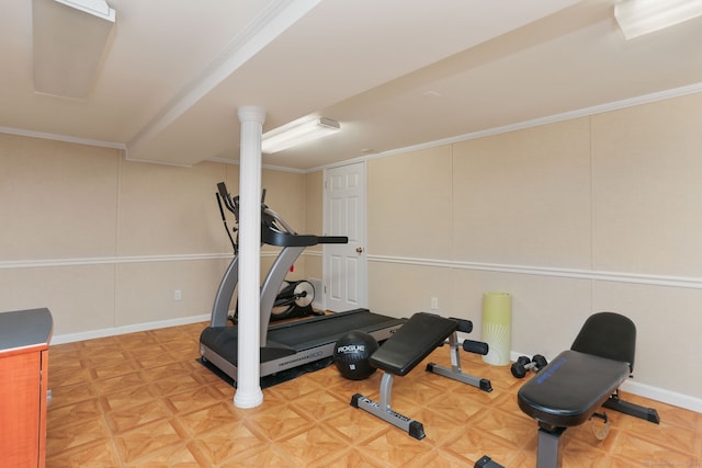 exercise room featuring a decorative wall, crown molding, and baseboards