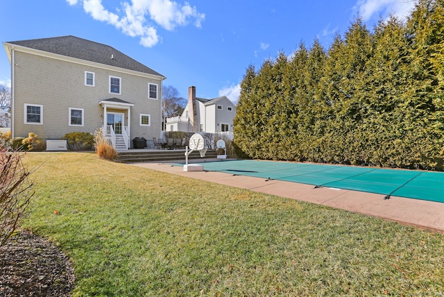 view of pool with a covered pool, a lawn, a patio area, and entry steps