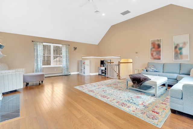 living area featuring baseboard heating, baseboards, visible vents, and wood finished floors