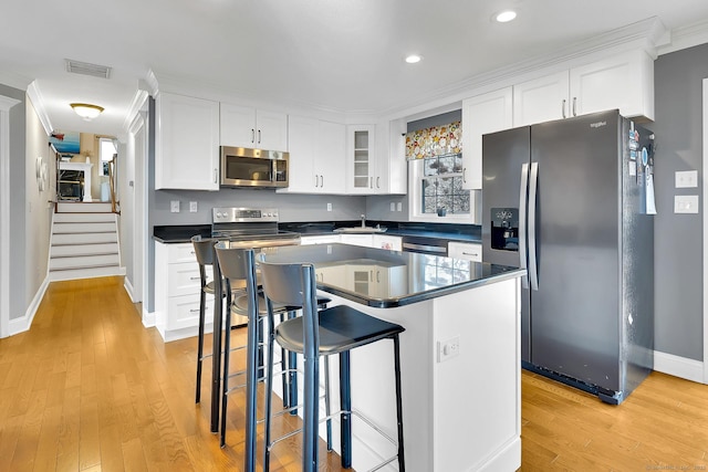 kitchen featuring visible vents, appliances with stainless steel finishes, white cabinetry, and light wood-style floors