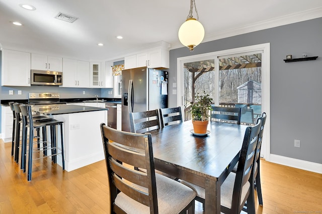 dining area with visible vents, baseboards, light wood-style flooring, recessed lighting, and ornamental molding