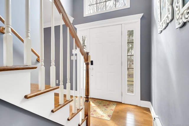 foyer featuring stairway, wood-type flooring, baseboards, and a wealth of natural light