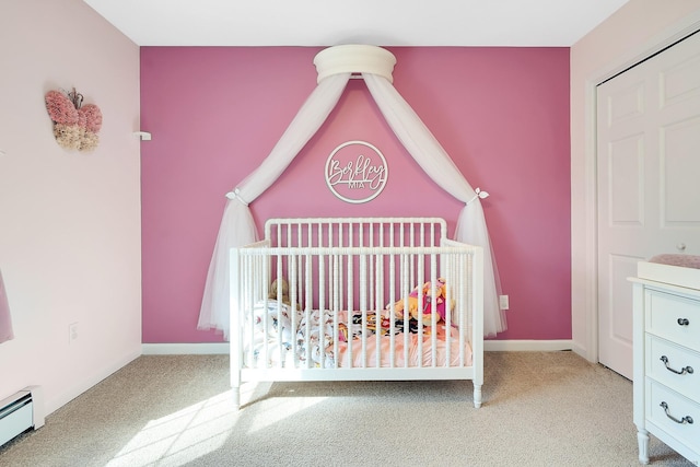 unfurnished bedroom with a nursery area, a baseboard radiator, baseboards, and carpet