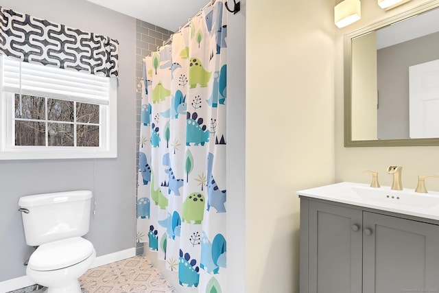 bathroom featuring a shower with curtain, toilet, vanity, and baseboards