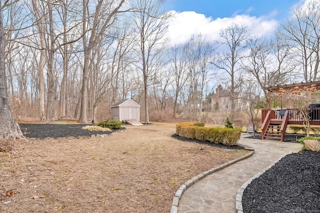 view of yard with a wooden deck, an outbuilding, and a storage shed