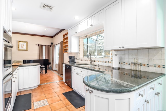 kitchen featuring visible vents, a sink, tasteful backsplash, black dishwasher, and a peninsula