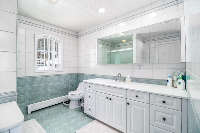 full bathroom featuring a baseboard heating unit, walk in shower, toilet, vanity, and tile walls