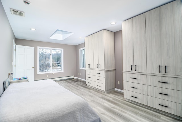 bedroom featuring visible vents, baseboard heating, recessed lighting, light wood-style flooring, and a skylight