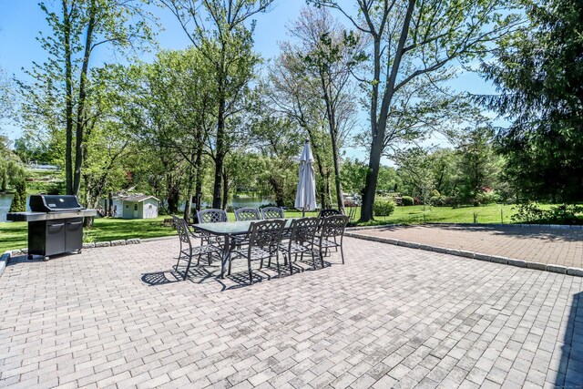38 N Lake Shore Dr, Brookfield, CT 06804 - view of patio with outdoor dining area, an outbuilding, a grill, view of scattered trees, and a shed