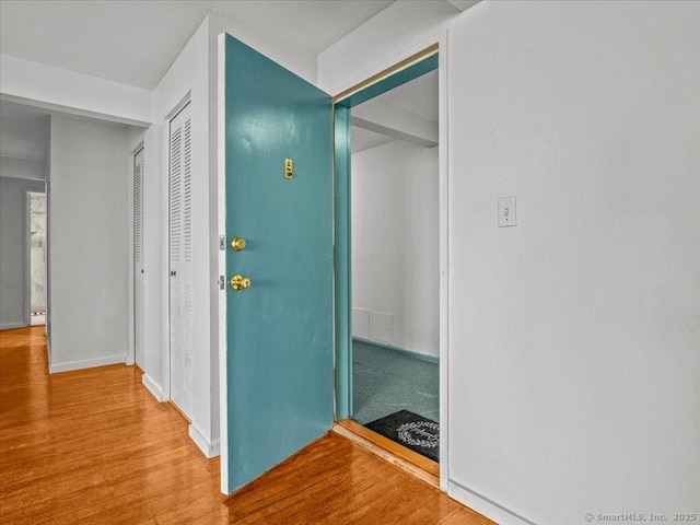 hallway featuring baseboards and wood finished floors