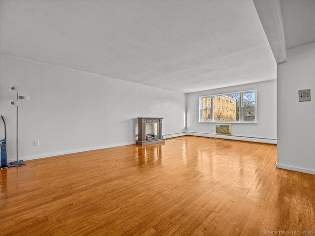 unfurnished living room featuring baseboards and hardwood / wood-style flooring