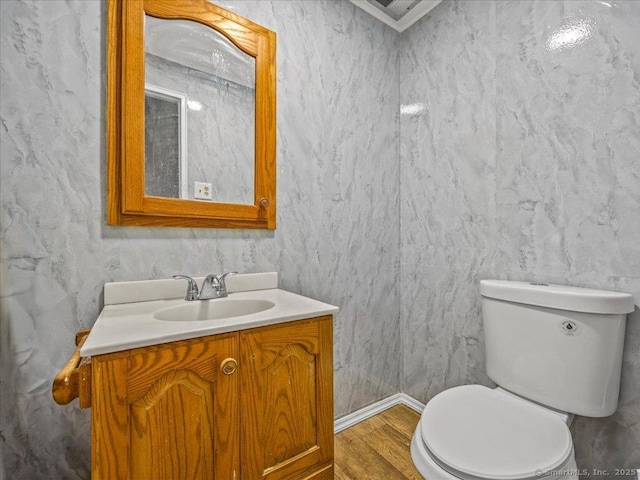 half bath featuring toilet, wood finished floors, and vanity