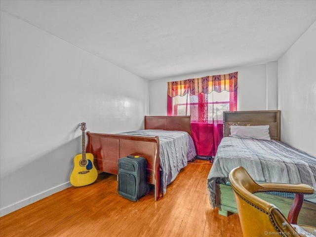 bedroom featuring baseboards and wood finished floors