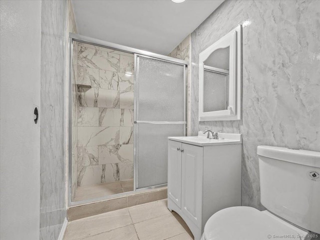 full bathroom featuring vanity, toilet, and a shower stall