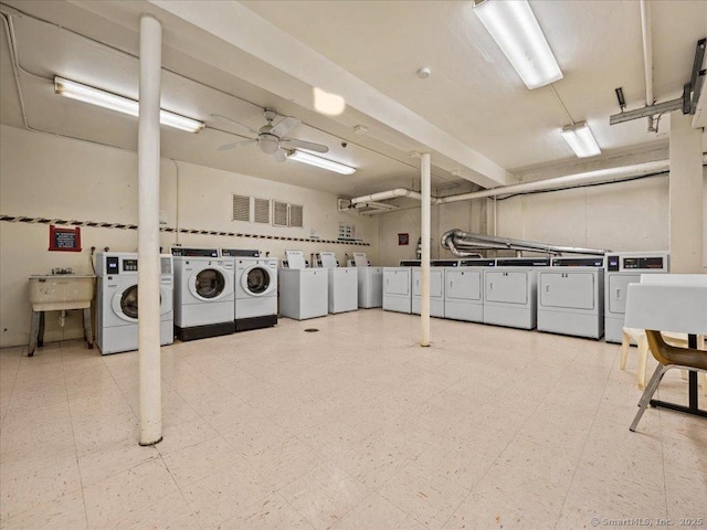 community laundry room featuring tile patterned floors, visible vents, a ceiling fan, a sink, and washing machine and clothes dryer